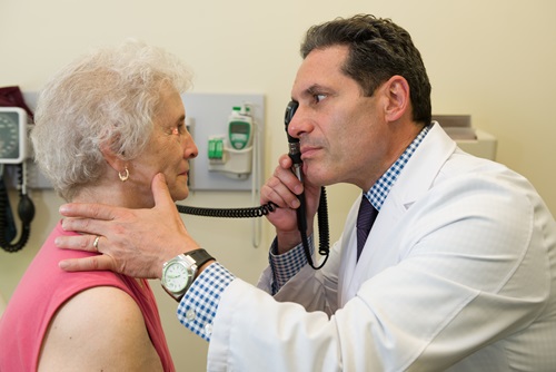 Paul Wright, MD, neurologist and senior vice president and system chair of the Nuvance Health Neuroscience Institute examines a patient in the neurology office. 