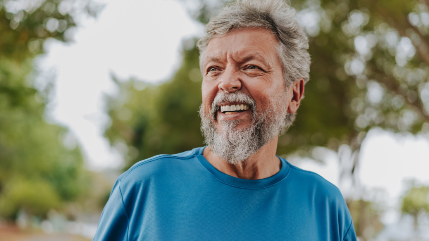 A happy Caucasian senior man in nature, smiling because he understands his colonoscopy results. 