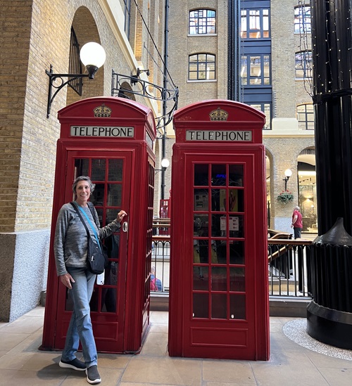 Northern Dutchess Hospital Breast Cancer Patient Carol Mackin standing next to historic phone booths in Europe.