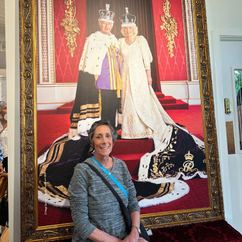 Northern Dutchess Hospital Breast Cancer Patient Carol Mackin sitting in front of a painting of the king and queen of England.