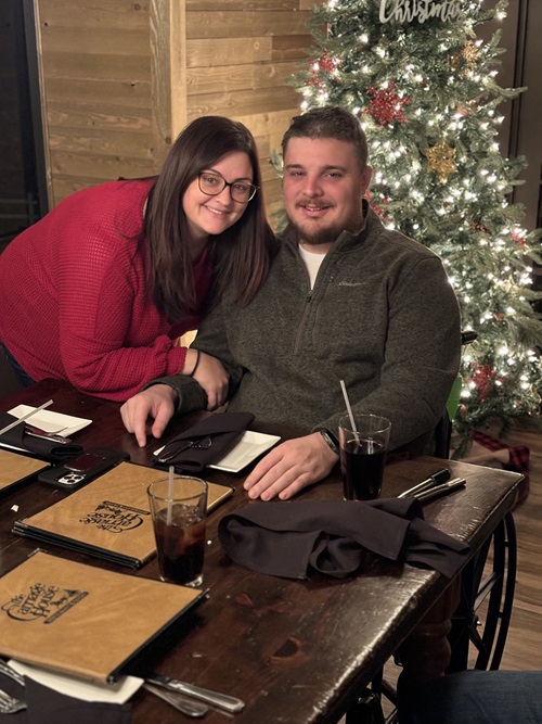 Samuel Neelands, Danbury Hospital spine surgery patient, sitting in front of a Christmas tree with his wife, Ashley.