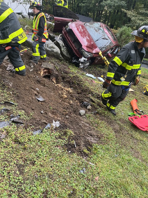 Samuel Neelands, Danbury Hospital spine surgery patient, in the car after the accident. It is crushed and on its side. First responders are on the scene.