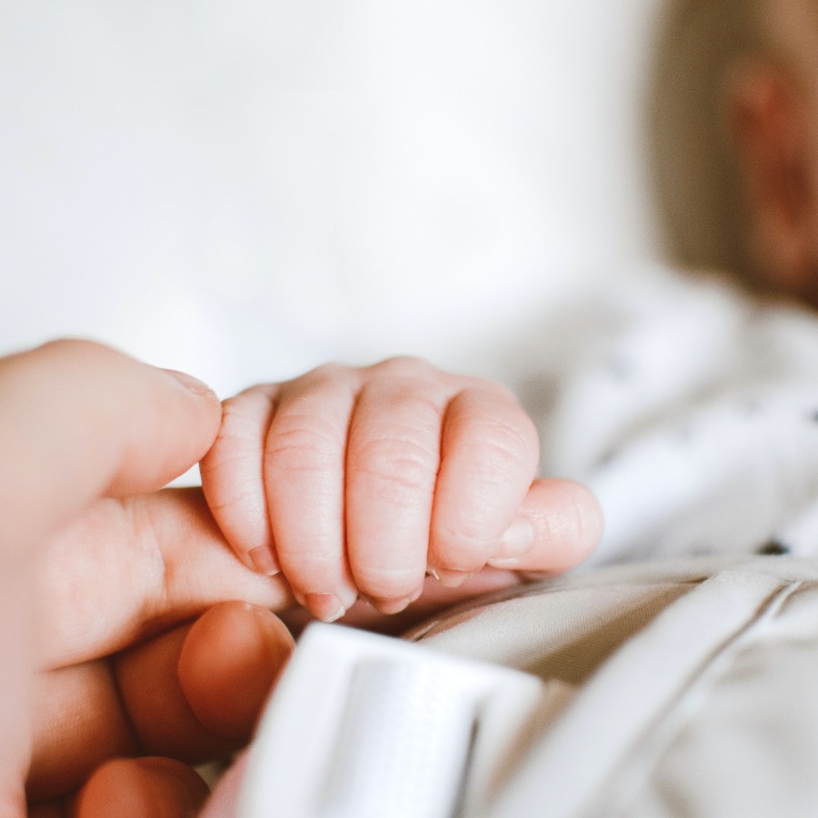 Person holding baby's hand