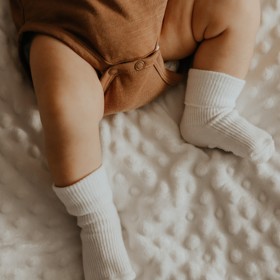 Baby in a brown onesie and socks