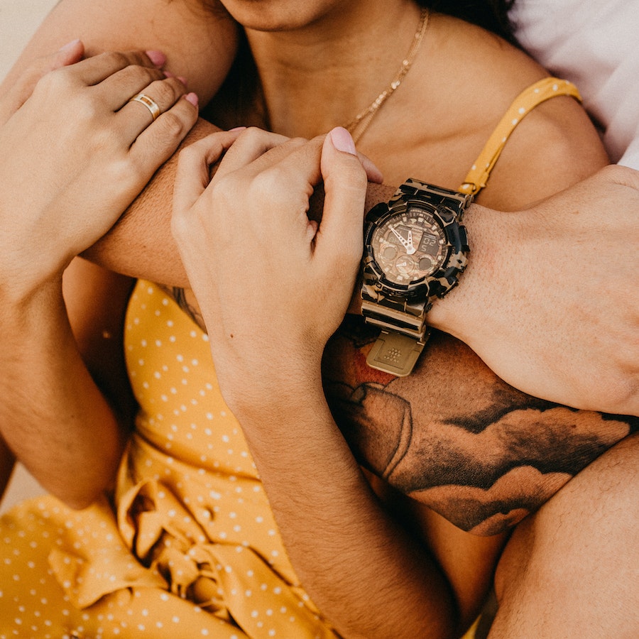 Man and woman in yellow polka-dot dress sitting and hugging