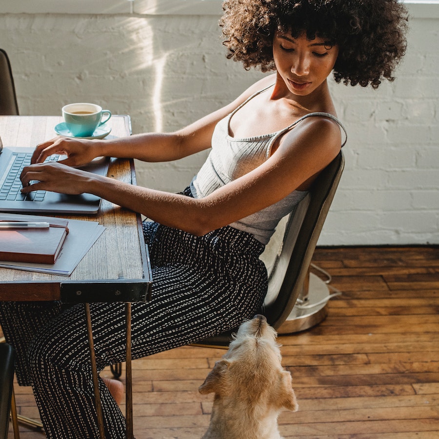 Woman working on her computer with her dog near 900x900