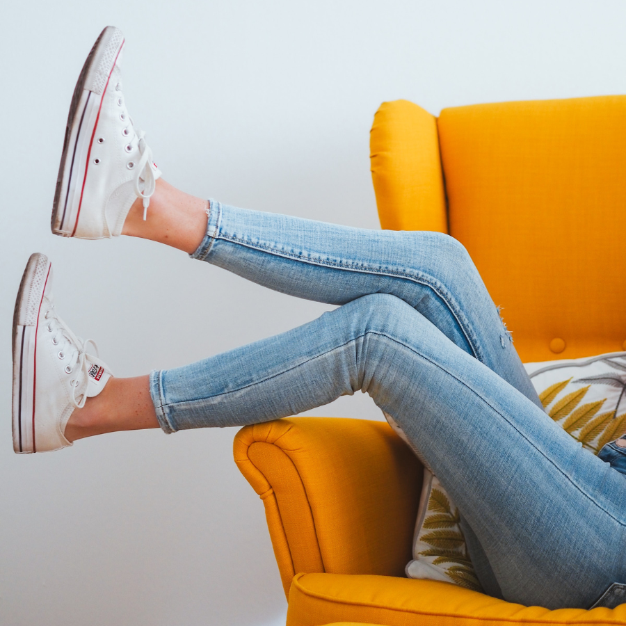 Womans legs overhanging a yellow chair 