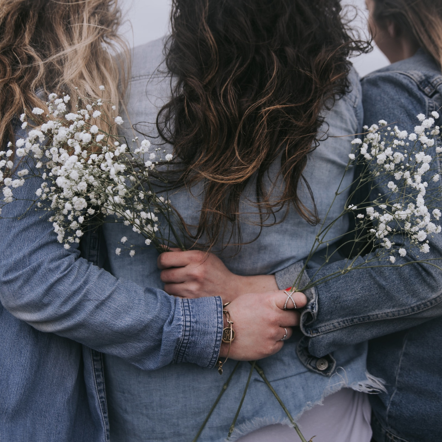 Women in jean jackets holding baby breathe