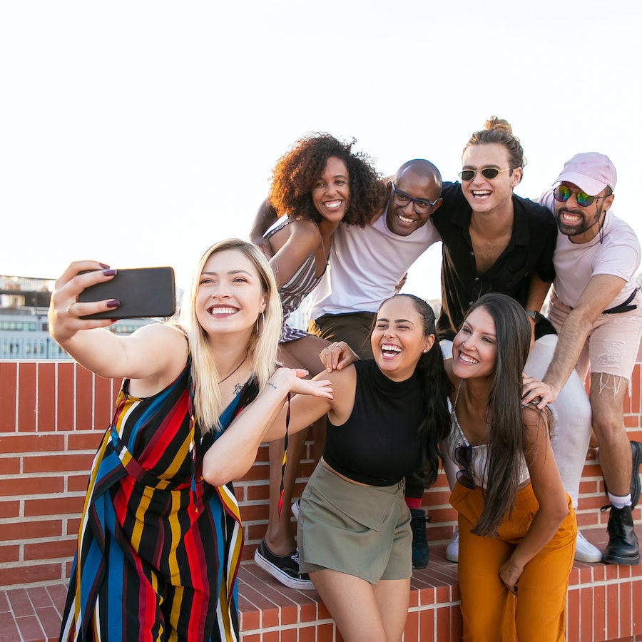 Young diverse men and women taking a selfie